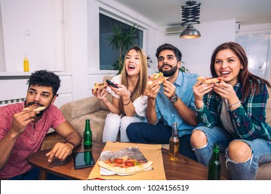 Group Of Young Friends Eating Pizza And Watching Tv.Home Party.Fast Food Concept.