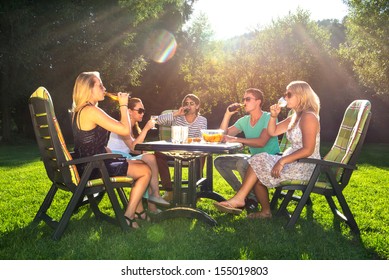 Group Of Young Friends Enjoying A Garden Party On A Sunny Afternoon