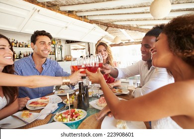 Group Of Young Friends Enjoying Meal In Outdoor Restaurant