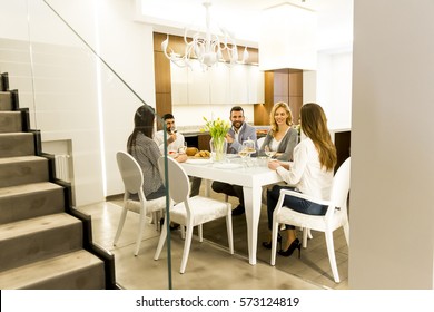 Group Of Young Friends Having Dinner At Home And Toasting With White Wine