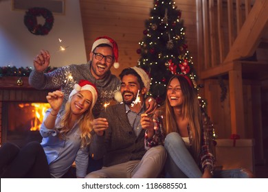 Group of young friends having fun at a New Year's celebration, holding sparklers at a midnight countdown - Powered by Shutterstock