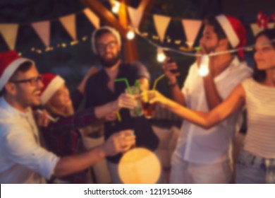 Group of young friends having fun at an outoodr poolside New Year's Eve party, making a midnight countdown toast. Blurred people background - Powered by Shutterstock