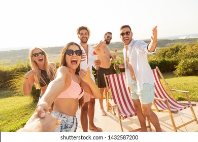 Group Of Young Friends Having Fun At A Poolside Summertime Party, Drinking Beer And Inviting More Friends To Join Them