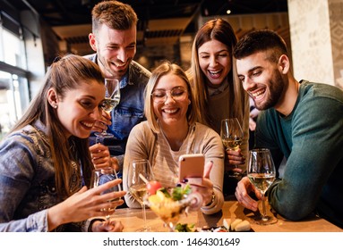 Group of young friends having fun in restaurant, talking and laughing while dining at table. - Shutterstock ID 1464301649