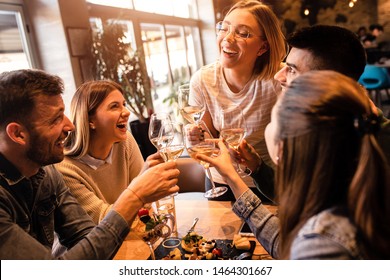 Group of young friends having fun in restaurant, talking and laughing while dining at table. - Shutterstock ID 1464301667