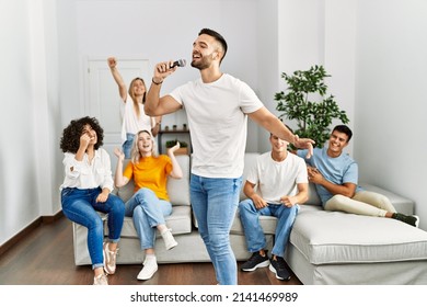 Group of young friends having party singing song using microphone at home. - Powered by Shutterstock