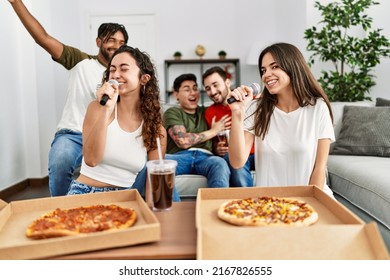 Group of young friends having party eating italian pizza and singing song at home. - Powered by Shutterstock