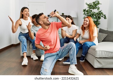 Group of young friends having party singing song using microphone at home. - Powered by Shutterstock