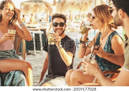 Group of young friends having a party at the beach bar.