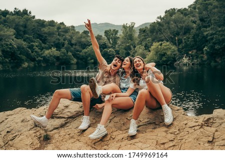 Group of young friends hiking on a lake vacation.