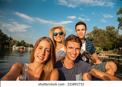 Group Of Young Friends On A Boat Enjoying Sunny Day And Taking Selfie