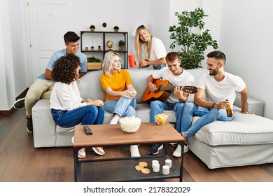 Group of young friends on party smiling happy and playing classical guitar at home. - Powered by Shutterstock