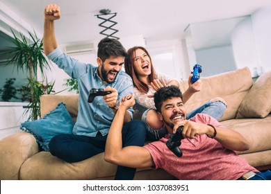 Group Of Young Friends Play Video Games Together At Home.