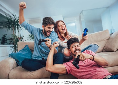 Group Of Young Friends Play Video Games Together At Home.