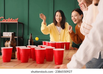 Group of young friends playing beer pong at party - Powered by Shutterstock