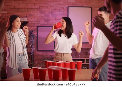 Group of young friends playing beer pong at party - Powered by Shutterstock