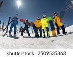 Group of young friends skiers and snowboarders are having fun and posing at ski slope. Ski holidays or resort concept