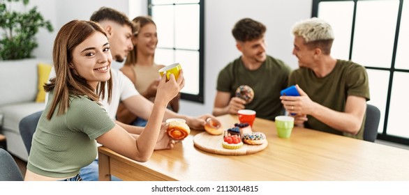 Group of young friends smiling happy having breakfast sitting on the table at home.