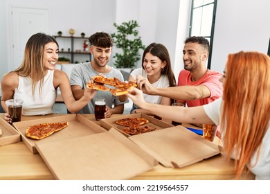 Group of young friends smiling happy eating italian pizza sitting on the table at home. - Powered by Shutterstock