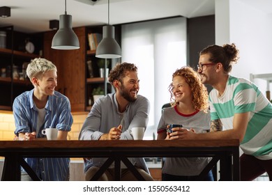 Group Of Young Friends Socializing At The Kitchen And Drinking Coffee