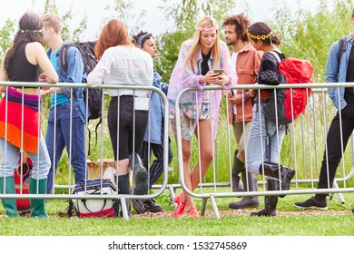 Gruppe junger Freunde, die beim Eintritt in die Musikfestivals hinter der Barriere warten
