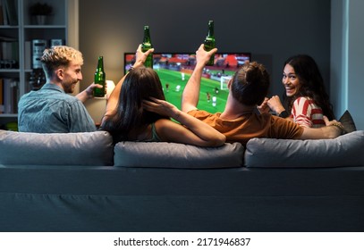 Group of young friends watching a football match on TV together and cheering for their team - Powered by Shutterstock