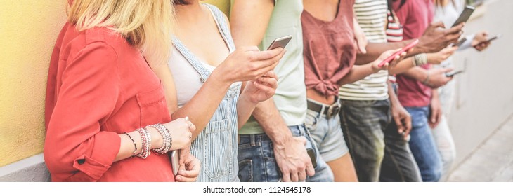 Group of young friends watching smart mobile phones - Teenagers addiction to new technology trends - Concept of youth, tech, social network and friendship - Focus on two close-up phones