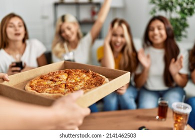 Group Of Young Friends Woman Surprise For Italian Pizza Sitting On The Sofa At Home.