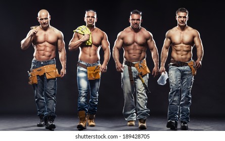 Group of young handsome builder posing, on dark background