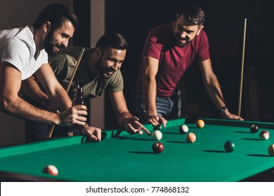 group of young handsome men playing in pool at bar 