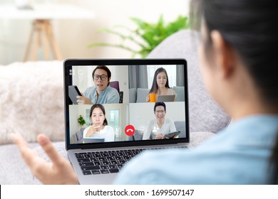 Group Of Young Happy Asian Work From Home Meeting Or Brainstorming Online Video Conference Application On 5G Internet With Covid Coronavirus Business Continuity Plan Via Tablet Or Notebook Computer.