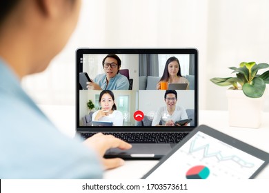 Group Of Young Happy Asian Work From Home Meeting Or Brainstorming Online Video Conference Application On 5G Internet With Covid Coronavirus Business Continuity Plan Via Tablet Or Notebook Computer.