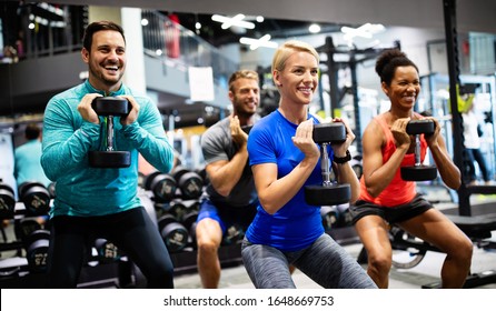 Group of young happy fit people doing exercises in gym - Powered by Shutterstock