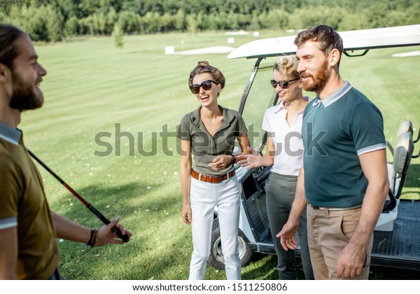 Group of\
a young happy friends gathering together before the golf game near\
the car on a playing course on a sunny\
day