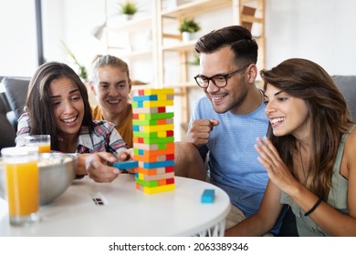 Group Of Young Happy Friends Having Fun Playing Wood Board Game