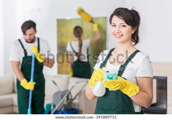 Group of young hard working professional\
cleaners in dirty\
apartment