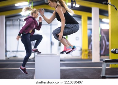 group of young healthy athletic people training jumping on fit box at cross fitness gym - Shutterstock ID 1110330407