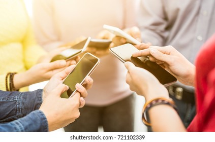 Group Of Young Hipsters Holding Phone In Hands. Friends Having Fun Together With Smartphones.