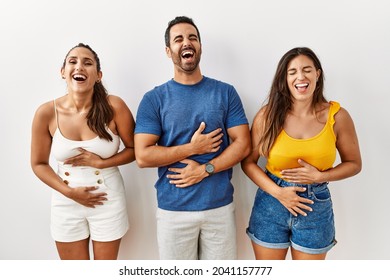 Group Of Young Hispanic People Standing Over Isolated Background Smiling And Laughing Hard Out Loud Because Funny Crazy Joke With Hands On Body. 