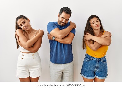 Group Of Young Hispanic People Standing Over Isolated Background Hugging Oneself Happy And Positive, Smiling Confident. Self Love And Self Care 