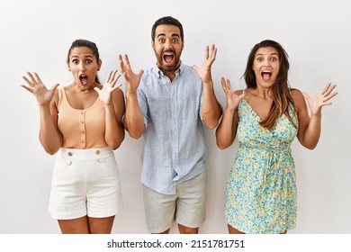 Group Of Young Hispanic People Standing Over Isolated Background Celebrating Victory With Happy Smile And Winner Expression With Raised Hands 