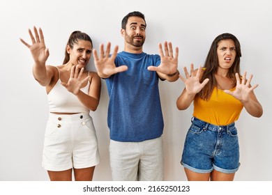 Group Of Young Hispanic People Standing Over Isolated Background Afraid And Terrified With Fear Expression Stop Gesture With Hands, Shouting In Shock. Panic Concept. 