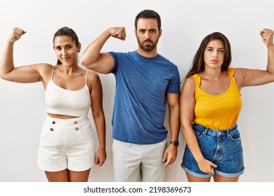 Group Of Young Hispanic People Standing Over Isolated Background Strong Person Showing Arm Muscle, Confident And Proud Of Power 