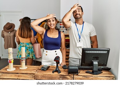 Group of young hispanic people working as manager at retail boutique stressed and frustrated with hand on head, surprised and angry face 