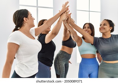 Group Of Young Hispanic Sporty Women Smiling Happy High Five With Hands Raised Up At Sport Center.