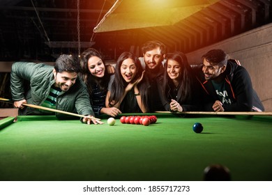 A Group Of Young Indian Asian Young People Or Friends Playing Fun Billiards, Snooker Or Pool