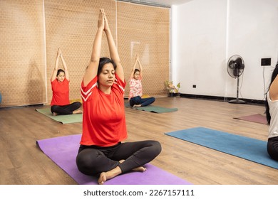 Group of young indian women practicing yoga meditation exercise together at indoor studio, Asian Sporty Girls workout, full length. Lotus pose. - Powered by Shutterstock