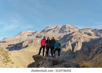 Group Of Young Latin Women Hiking Trips On Mountain Vacation, Wild Adventure. Background For Travel Concept.