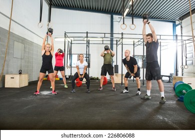 Group Of Young Male And Female Athletes Lifting Kettlebells 