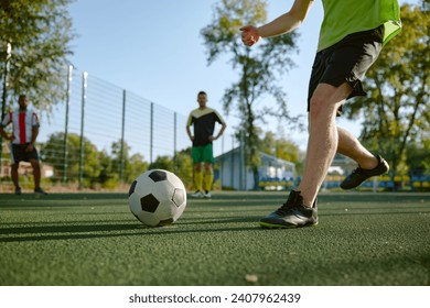 Group of young male friends playing football outdoors in summer day - Powered by Shutterstock